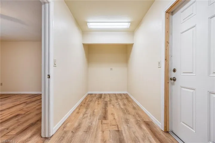 Laundry area with light hardwood / wood-style flooring