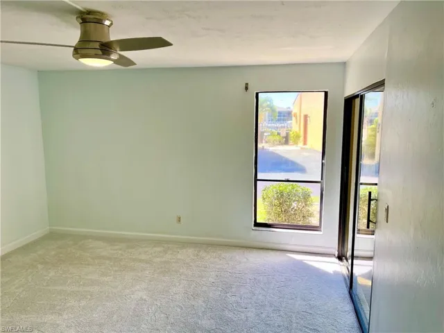 Empty room featuring light colored carpet and ceiling fan