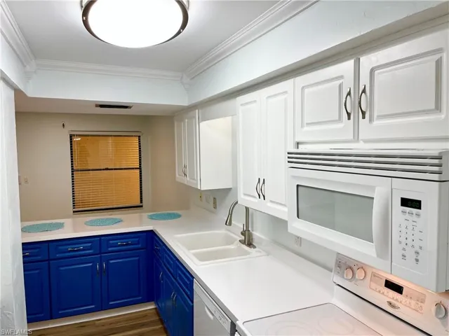 Kitchen with white cabinetry, stainless steel dishwasher, stove, crown molding, and sink