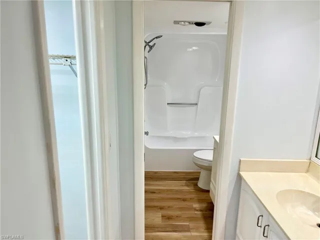 Bathroom featuring vanity, wood-type flooring, and toilet