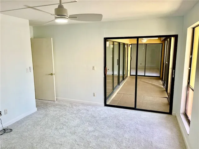Unfurnished room with light colored carpet and ceiling fan