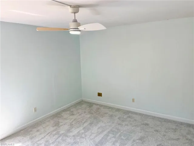 Carpeted spare room with ceiling fan