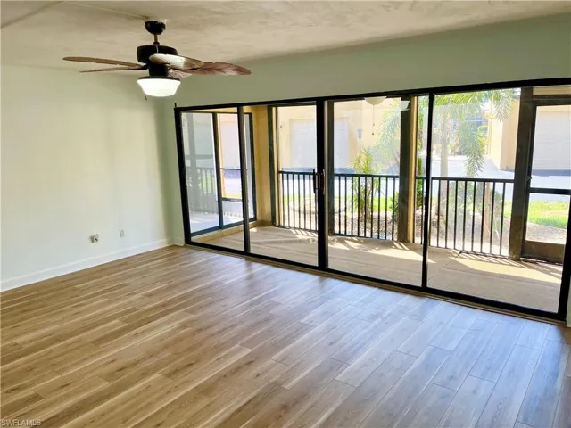 Unfurnished room with a wealth of natural light, hardwood / wood-style floors, and ceiling fan