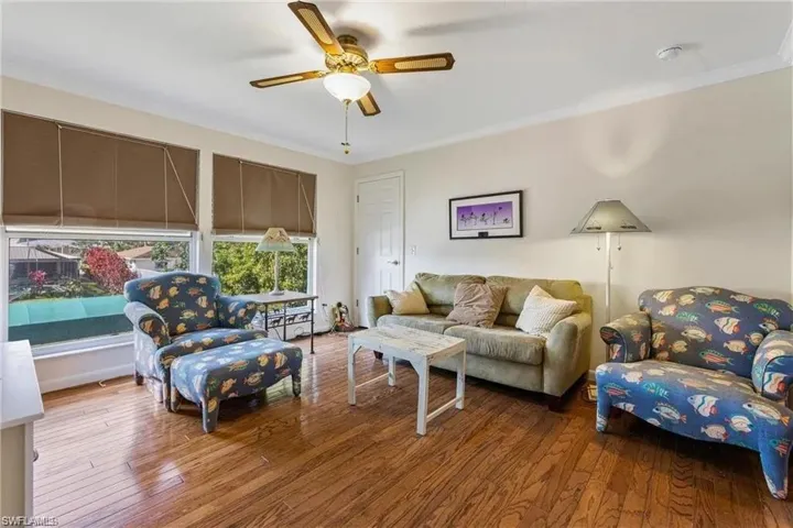 Living room with ornamental molding, hardwood / wood-style floors, and ceiling fan