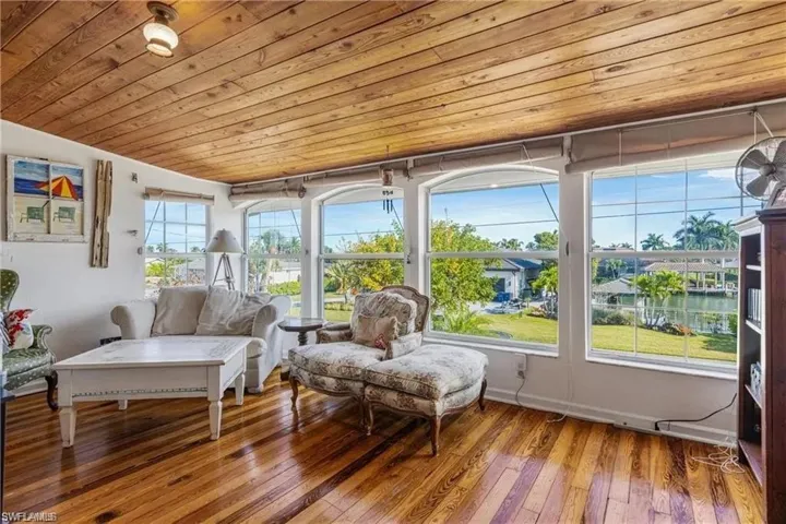Sunroom / solarium with wood ceiling and a water view
