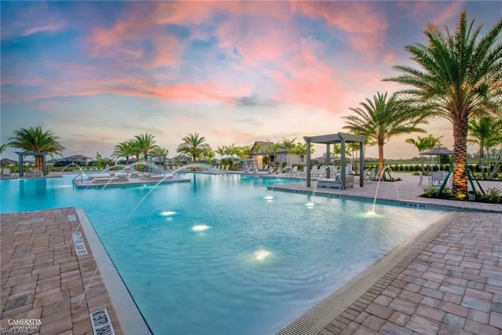 Pool at dusk with pool water feature and a patio area