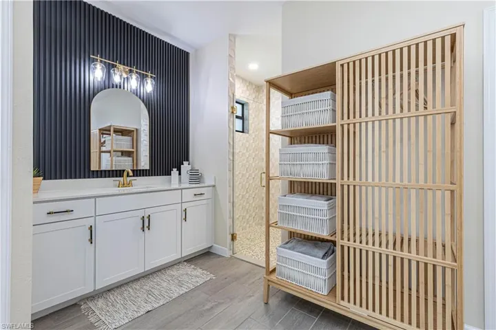 Bathroom featuring baseboards, vanity, and wood finished floors