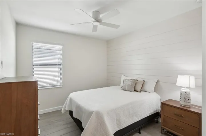 Bedroom with baseboards, a ceiling fan, and light wood-style floors