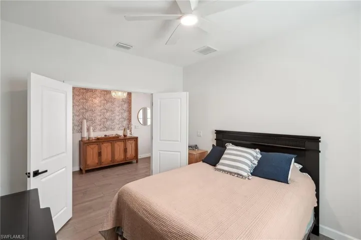 Bedroom featuring light wood-type flooring, baseboards, visible vents, and ceiling fan
