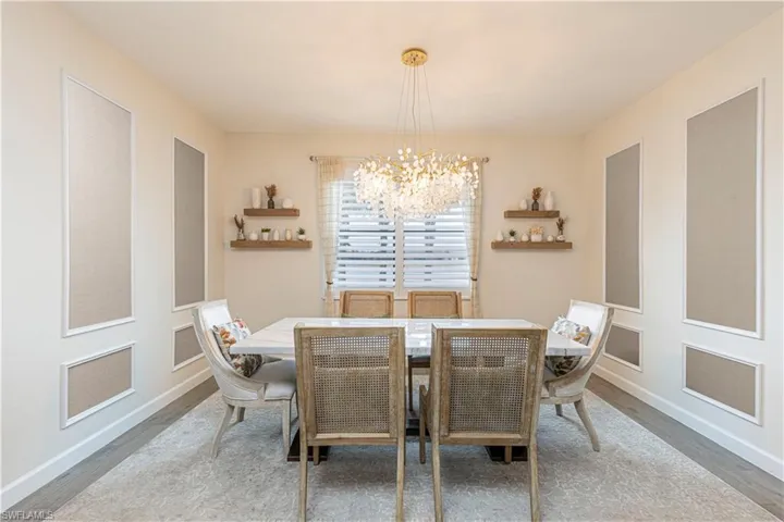 Dining room featuring a chandelier, baseboards, and wood finished floors