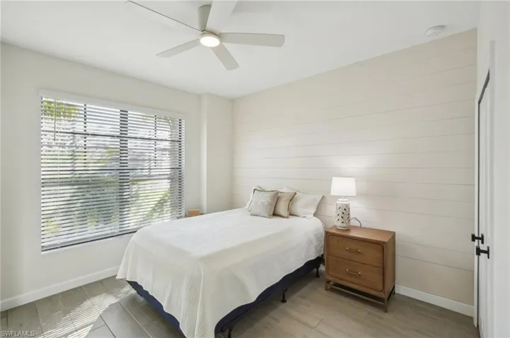 Bedroom with light wood-style flooring, baseboards, and a ceiling fan