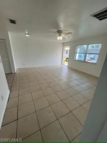 Empty room featuring light tile patterned floors and ceiling fan