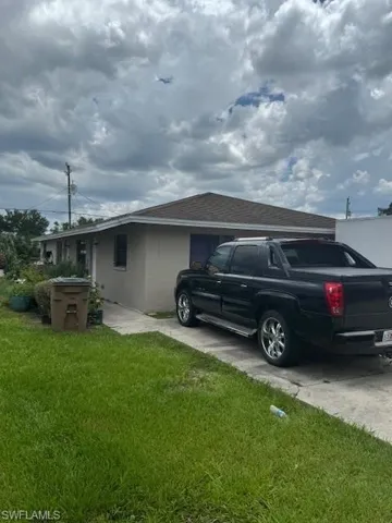 View of side of property featuring stucco siding and a lawn