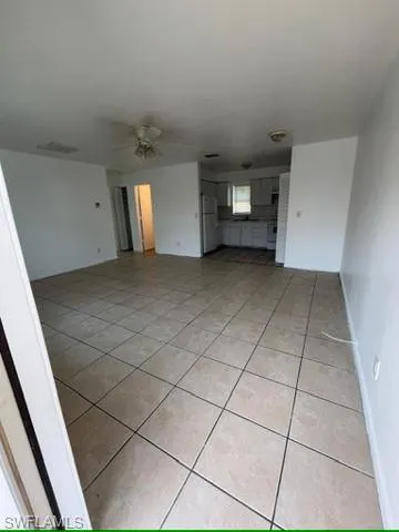 Unfurnished living room featuring light tile patterned floors and a ceiling fan