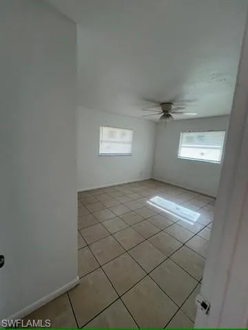 Unfurnished room with light tile patterned flooring and a ceiling fan