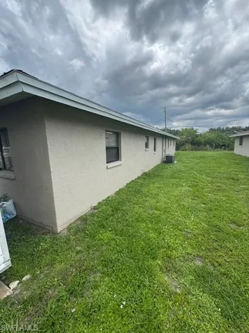 View of home's exterior featuring stucco siding and a lawn