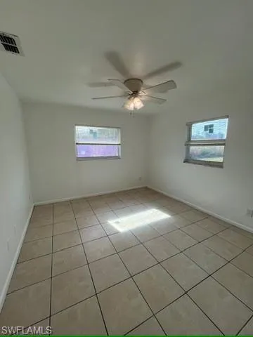 Unfurnished room featuring light tile patterned floors and ceiling fan