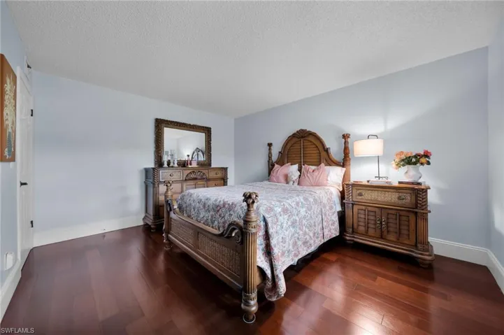 Bedroom featuring dark wood-style flooring and a textured ceiling