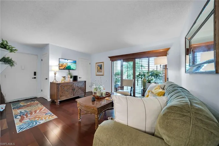 Living room with a textured ceiling and dark wood-style flooring