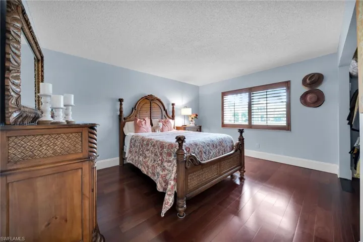 Bedroom with a textured ceiling and dark wood-type flooring