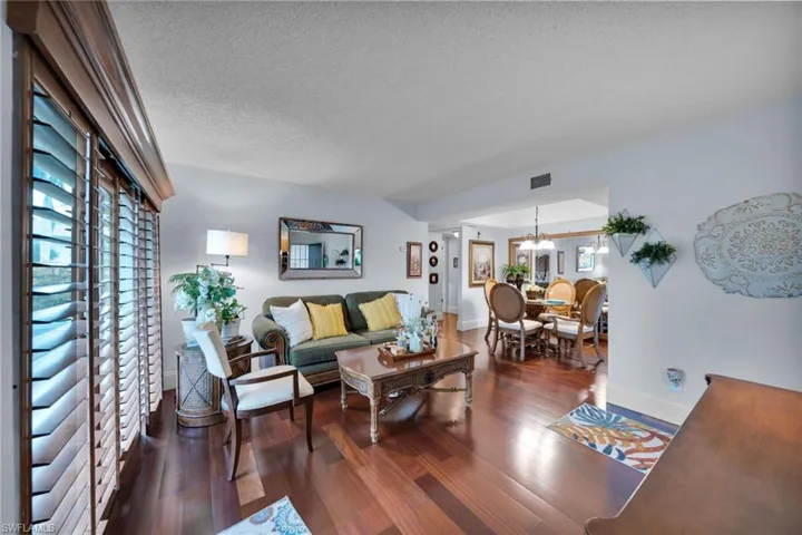 Living area featuring dark wood finished floors, a textured ceiling, and healthy amount of natural light