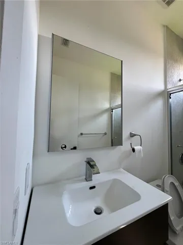 Full bath featuring vanity and an enclosed shower