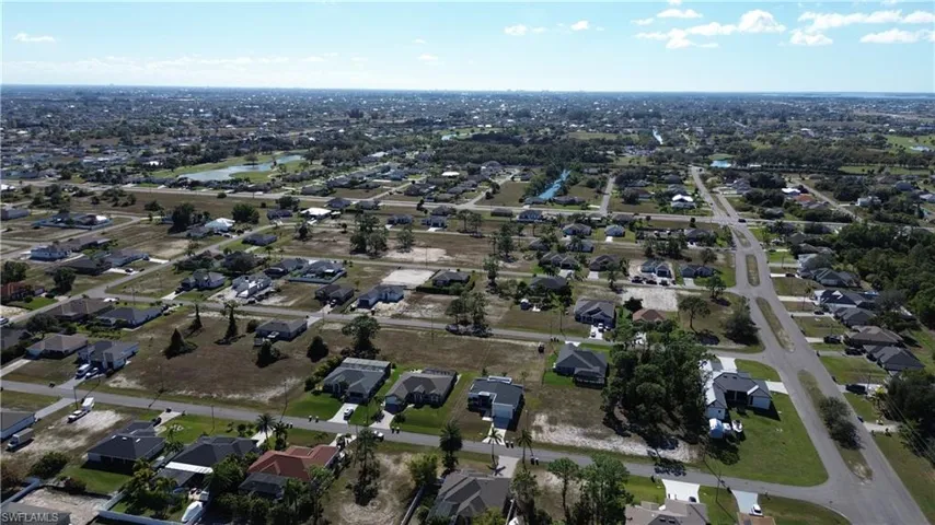 Aerial view of property and surrounding area with nearby suburban area
