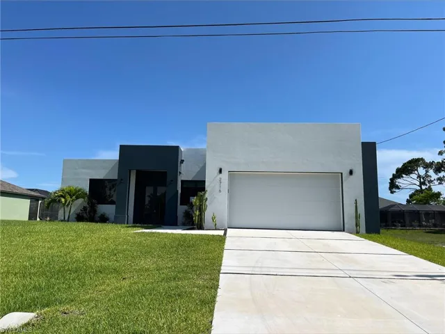 Contemporary home featuring a front yard and stucco siding