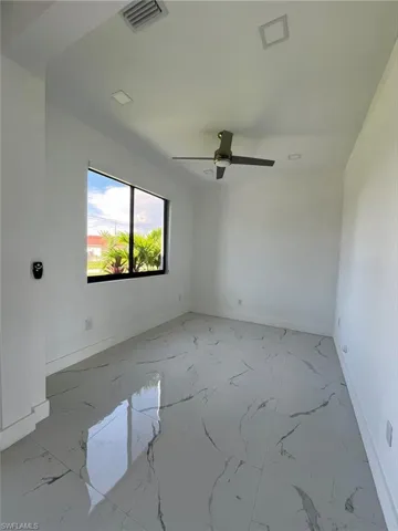Spare room with light marble finish flooring and baseboards