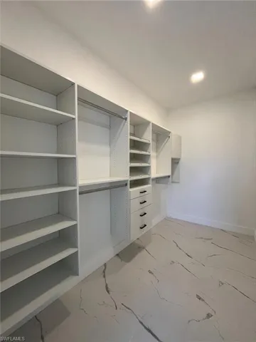 Walk in closet with light marble finish floors