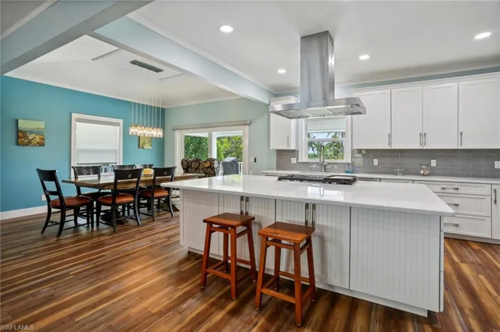 Kitchen featuring a center island, white cabinetry, dark hardwood / wood-style floors, and island exhaust hood