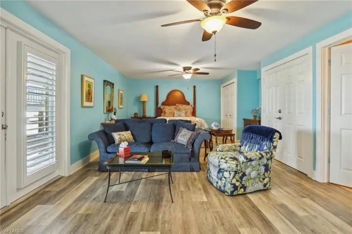 Living room featuring a healthy amount of sunlight, light wood-type flooring, and ceiling fan