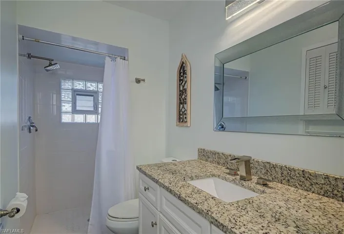 Full bath featuring vanity and a tile shower