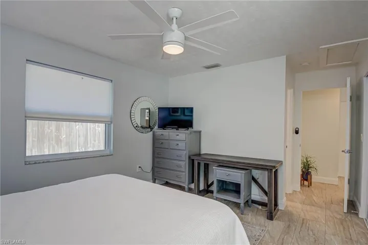 Bedroom featuring a ceiling fan and attic access