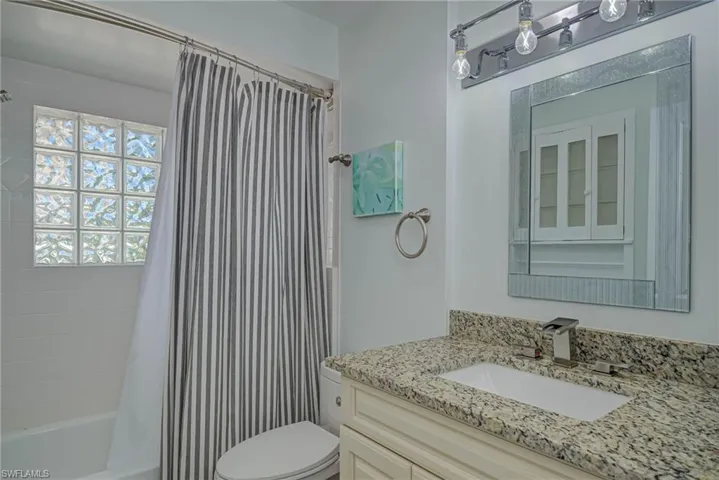 Bathroom featuring shower / tub combo with curtain and vanity
