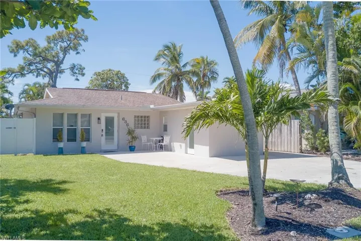 Back of house featuring stucco siding, a patio, and concrete driveway