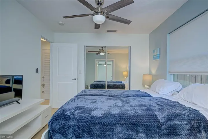 Bedroom with ceiling fan, a closet, and light wood-type flooring