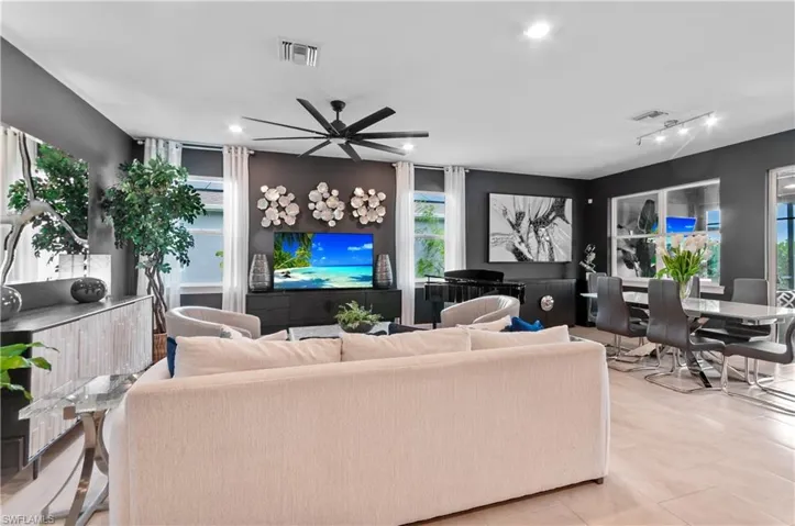Open-concept living and dining area featuring dark accent walls and light-toned flooring