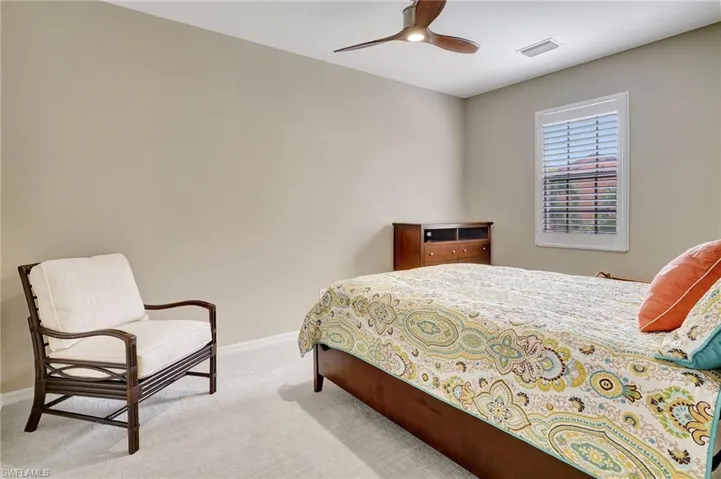 Carpeted bedroom featuring ceiling fan