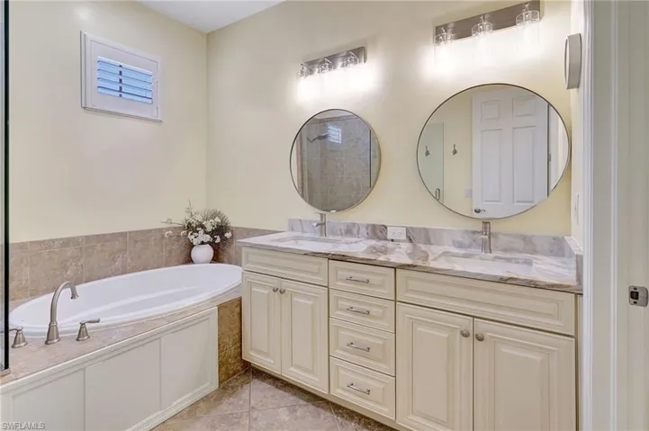 Bathroom with a washtub, tile patterned flooring, and vanity