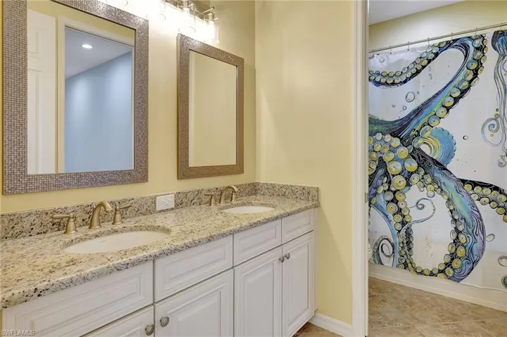 Bathroom with tile patterned floors, vanity, and walk in shower