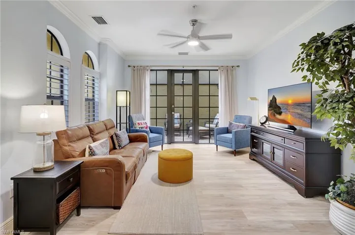 Living room with ceiling fan, light hardwood / wood-style floors, ornamental molding, and french doors