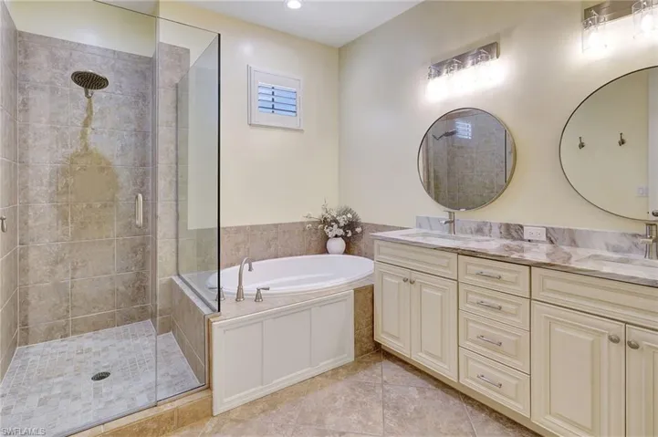 Bathroom with tile patterned flooring, vanity, and shower with separate bathtub