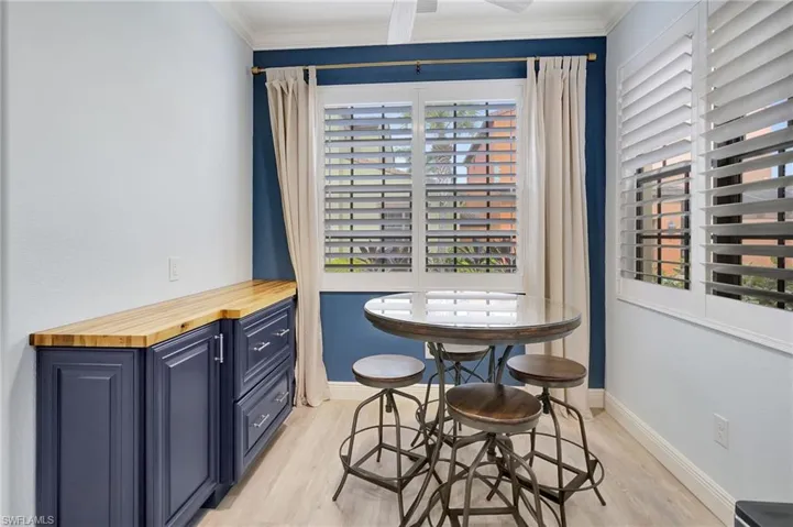 Dining space with light wood-type flooring and ornamental molding