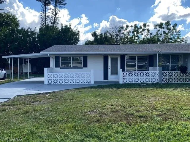 View of front of property with a front lawn and a carport