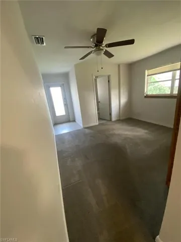 Carpeted spare room with ceiling fan