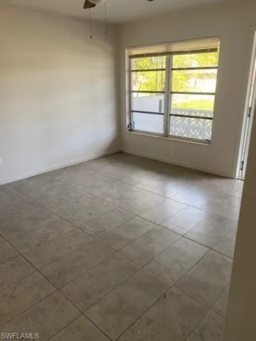 Tiled spare room with a wealth of natural light and ceiling fan