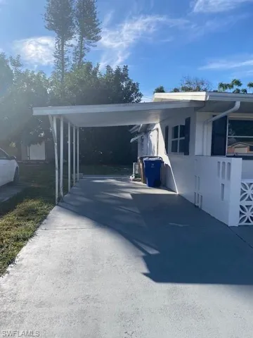 View of parking / parking lot with a carport