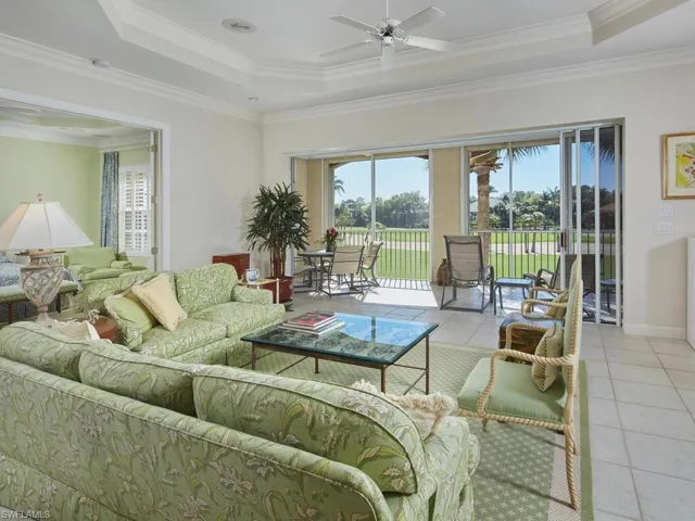 Bright and airy living room with large windows and serene golf course views.