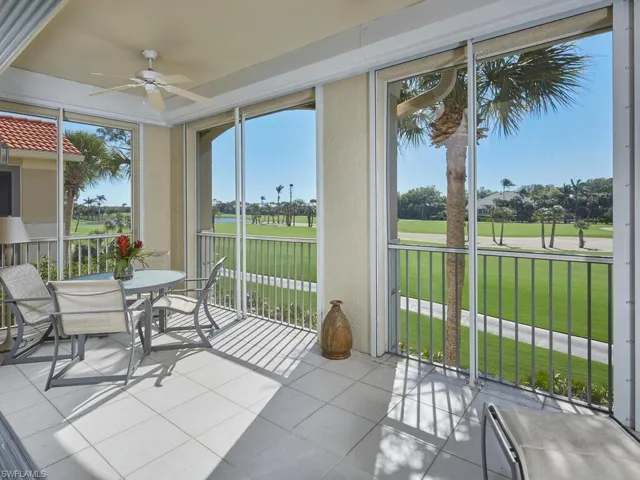 Expansive screened-in lanai with breathtaking golf course views, perfect for outdoor relaxation.